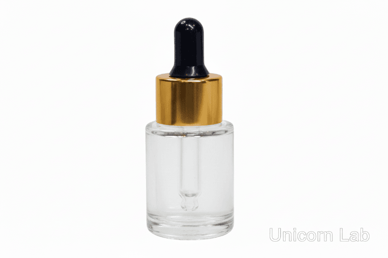 Clear 15ml flat shoulder glass dropper bottle with gold cap on a white background