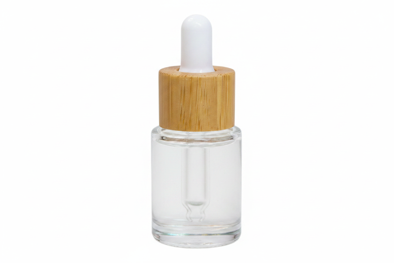 Clear glass dropper bottle with a wooden cap on a white background