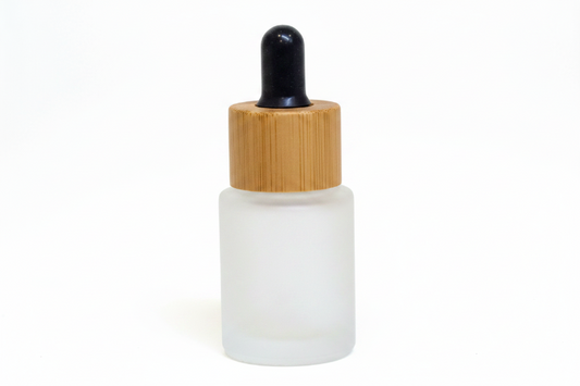 White frosted 15ml flat shoulder glass dropper bottle with a bamboo cap on a white background