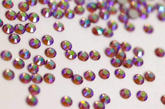 Bulk factory pack of Light Amethyst AB SS6 (2.0mm) soft purple iridescent glass flatback rhinestones for professional nail art.