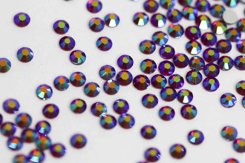 Bulk factory pack of Dark Siam AB SS6 (2.0mm) deep red iridescent glass flatback rhinestones for professional nail art.