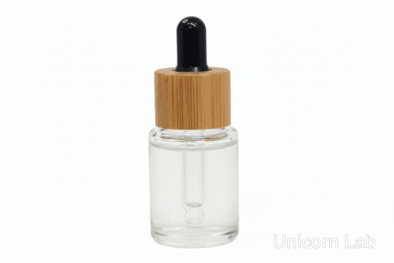 Clear 5ml flat shoulder glass dropper bottle with a bamboo cap on a white background