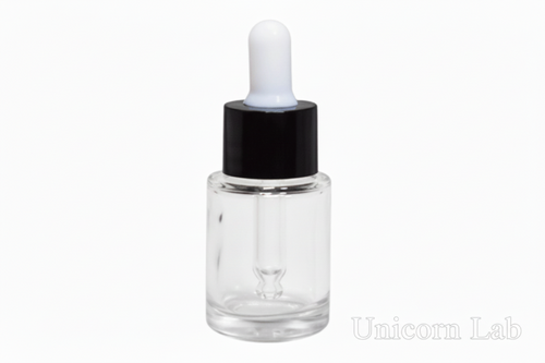 Clear dropper bottle with black cap on a pink background