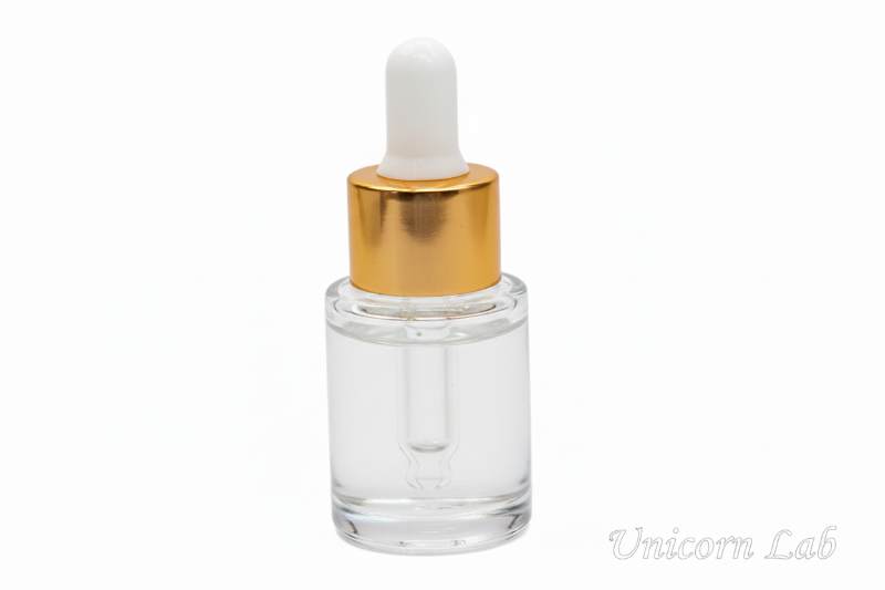 Glass dropper bottle with gold cap on a pink background