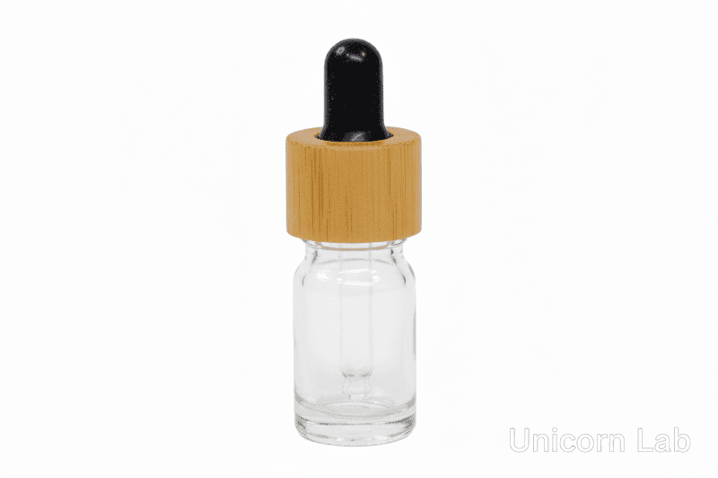 Clear glass  5ml round dropper bottle with a bamboo cap on a white background