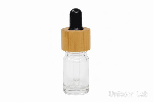 Clear glass  5ml round dropper bottle with a bamboo cap on a white background