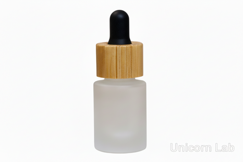 Frosted glass dropper bottle with a bamboo cap on a white background, branded 'Unicorn Lab'.