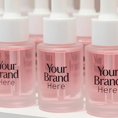 Pink serum bottles with 'Your Brand Here' text on a white background