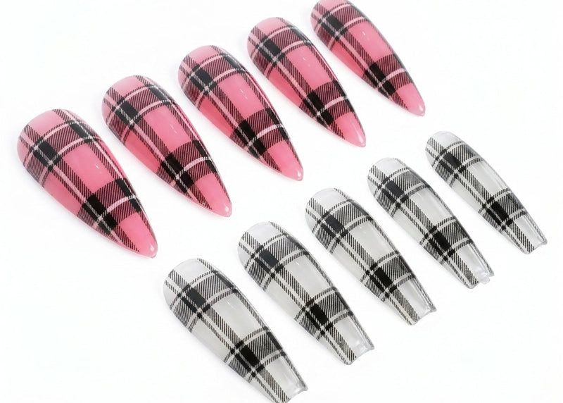 Plaid nail art tips in pink, black, and white on a white background