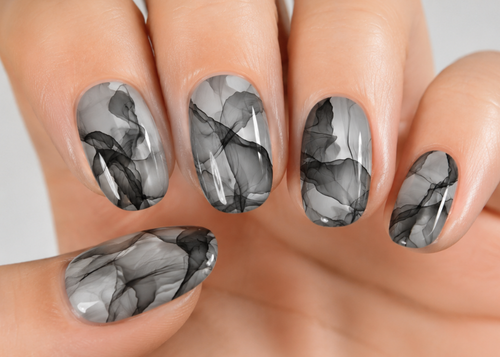 Nails with black and gray marble design on a neutral background
