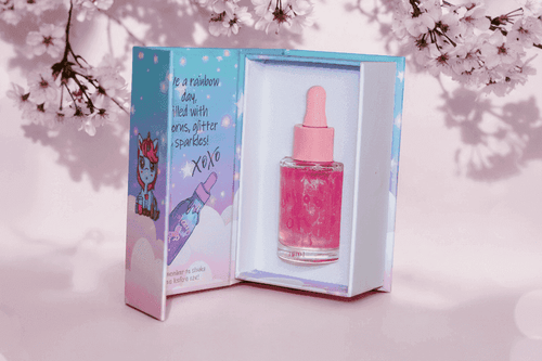 Pink bottle with dropper in a branded box against a cherry blossom background