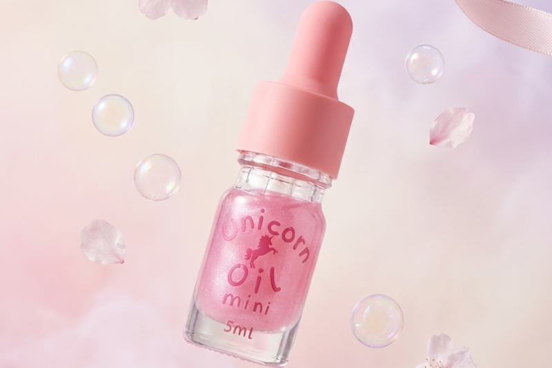 Pink bottle labeled 'Unicorn Oil' with a dropper on a soft, pastel background.