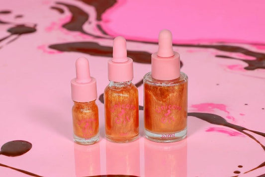 Three cuticle oil dropper bottles with a pink background