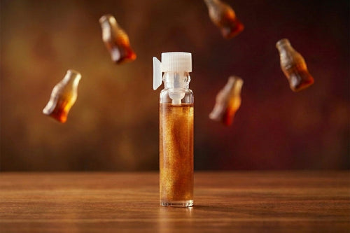 Vial of amber liquid with small bottles floating around on a wooden surface