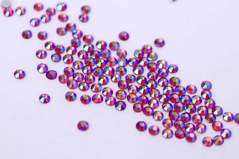 Bulk factory pack of Rose AB SS6 (2.0mm) pink iridescent glass flatback rhinestones for professional nail art.