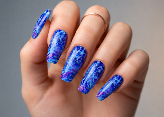 Hand with blue marbled nail polish on a neutral background