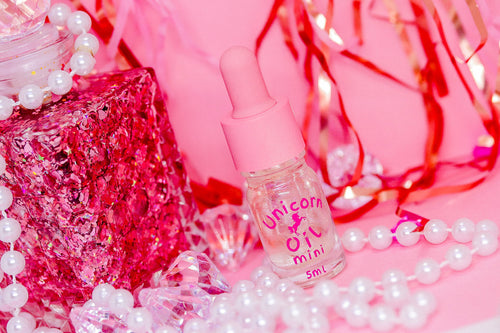 Eternal Amour Scented Unicorn Cuticle Oil 5ml mini near pearls on a pink themed backdrop - part of the unicorn oil range