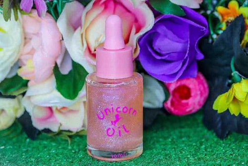 Floral Explosion Unicorn Cuticle Oil 30ml luxury bottle with pink lid in front of colorful flowers.