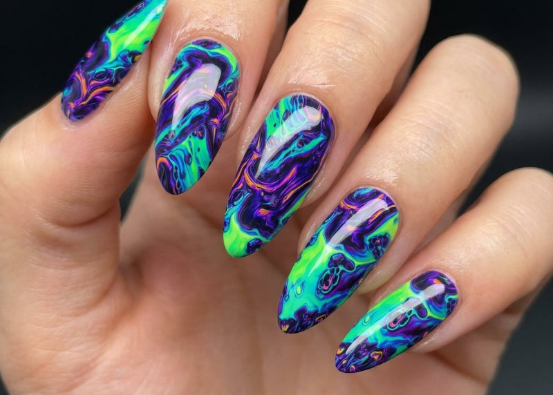 Hand with colorful, iridescent nail art on a dark background