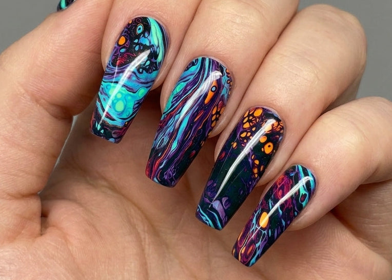 Hand with colorful marbleized nail art on a gray background