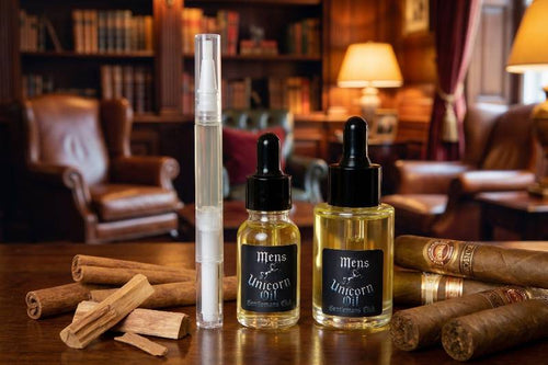 Two bottles of 'Men's Cuticle Oil' on a wooden table with cinnamon sticks and cigars in a cozy room setting.