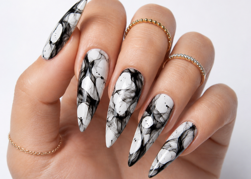 Hand with black and white marble nail art on a neutral background