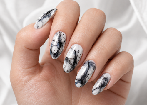 Hand with marbleized nail design on a white background