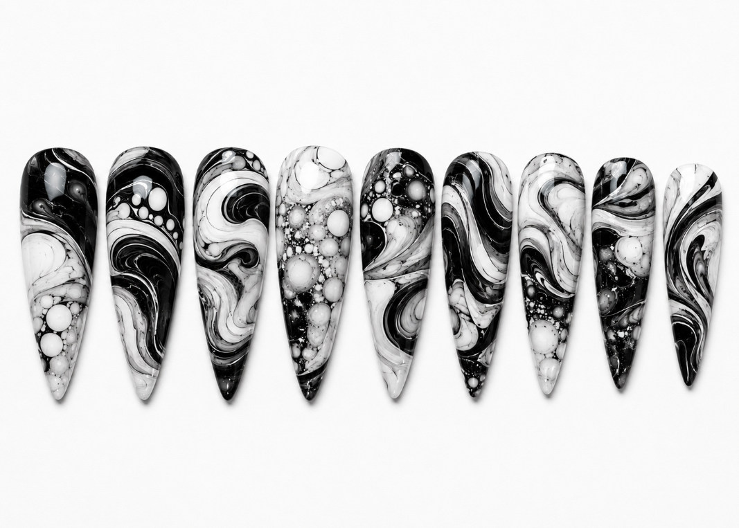 Marbled black and white nail art designs on a white background