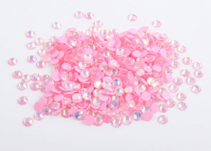 Pink rhinestones on a white background. Light Pink Luminous rhinestones ss6 micro nail gems australia. Large bulk pack stacked in a pile.