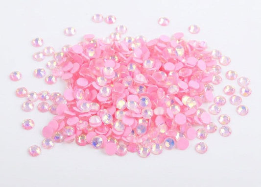 Pink rhinestones on a white background. Light Pink Luminous rhinestones ss6 micro nail gems australia. Large bulk pack stacked in a pile.