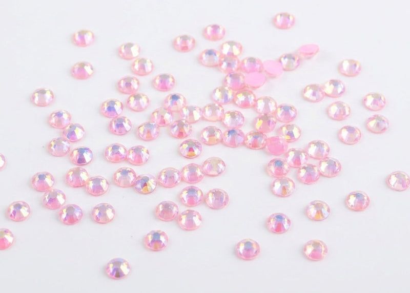 Pink rhinestones scattered on a white background. Light Pink Luminous rhinestones 2666 bulk wholesale rhinestones australia
