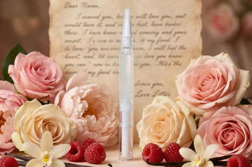 cuticle oil Pen with pink roses, raspberries, and vanilla beans on a textured paper background