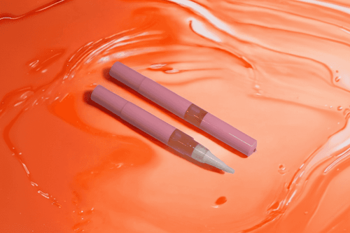 Mango & Guava Unicorn Cuticle Oil Pen on an orange liquid surface - from Australian retailer Unicorn Lab