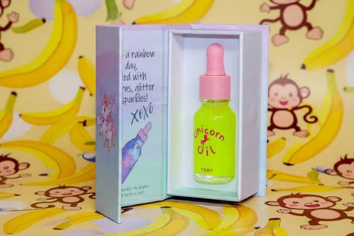 15ml glass dropper bottle  of Monkey Farts Unicorn Cuticle Oil featuring a tropical shimmering liquid.