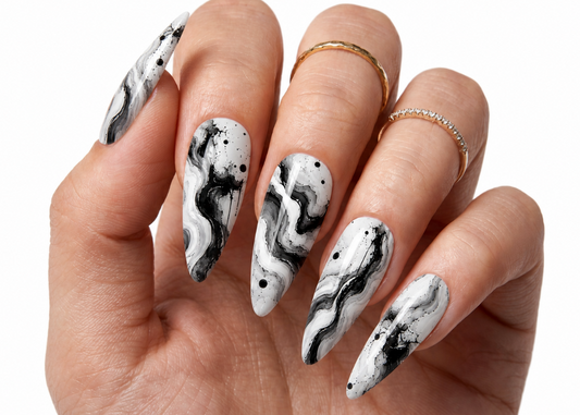 Hand with black and white marbled nail art on a white background