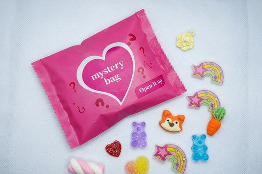 Pink Mystery Charm Bag surrounded by assorted colourful sweet-themed nail art charms.