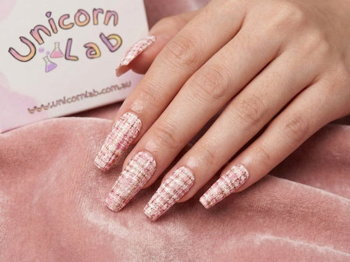 Hand with pink glittery nails on a pink surface, with 'Unicorn Lab' branding in the background. Soft Pink Tweed Waterslide nail Decals