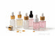 Set of skincare dropper bottles with various colored liquids on a light background. cuticle Oil Private label by Unicorn Lab