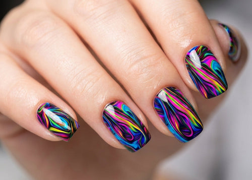 Hand with multicolored nail art on a blurred background