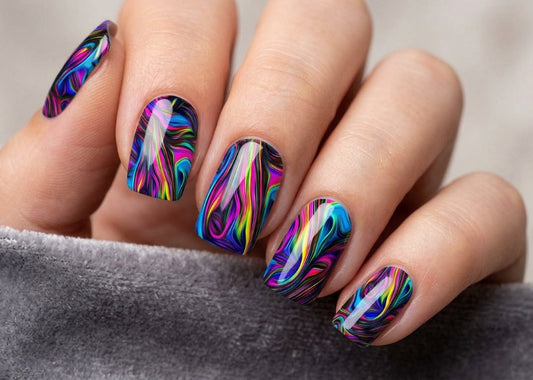 Multicolored nail art on a person's hand with a blurred background