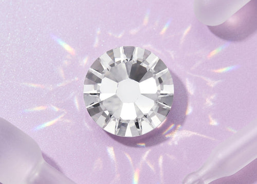 Clear gemstone on a light purple background. SS10 Crystal | Flatback Nail Crystals | Genuine Swarovski 2058 Rhinestones