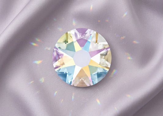 Multicolored gemstone on a gray fabric background. SS12 Crystal AB | Swarovski Crystals