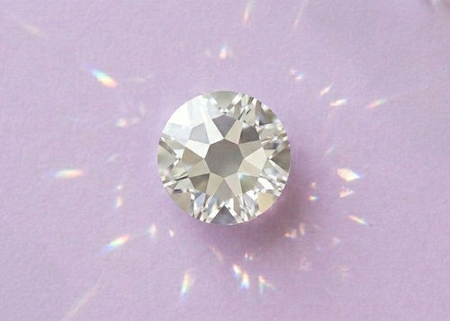 Clear gemstone on a light purple background