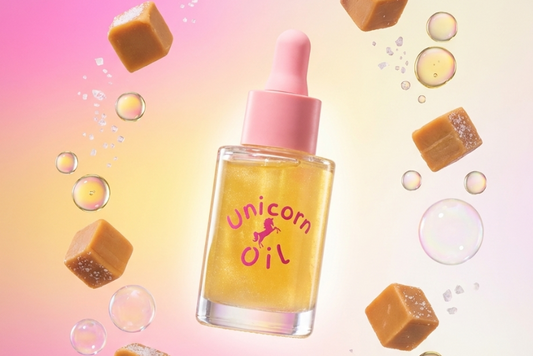 Salted Caramel Unicorn oil bottle with caramels and bubbles on a gradient background. 