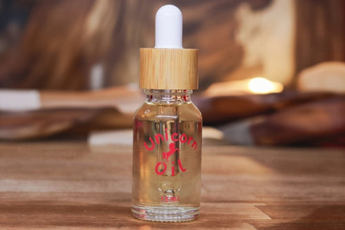 15ml glass bottle of organic Sandalwood Unicorn Cuticle Oil featuring a white dropper and clear, golden oil.