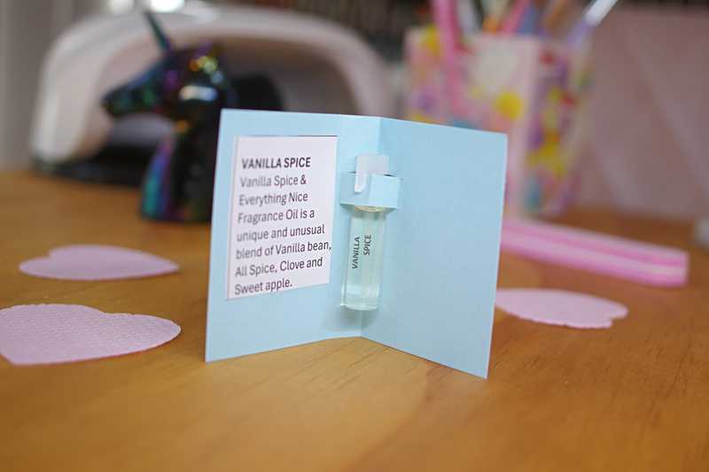Vanilla Spice & Everything Nice Unicorn Cuticle Oil in 1 ml sample size with fragrance notes card sitting on a nail desk