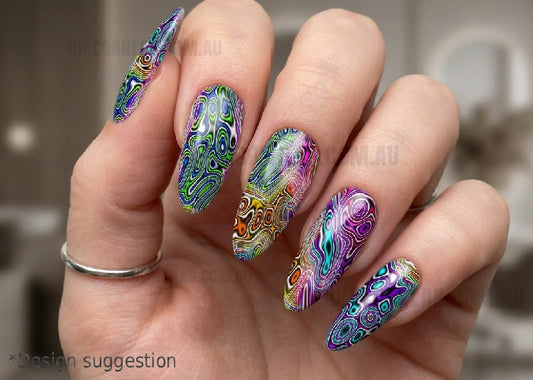 Hand with colorful paisley nail art on a blurred background