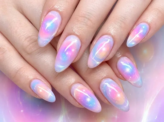 Nails with a gradient design in pink, purple, and blue on a blurred background