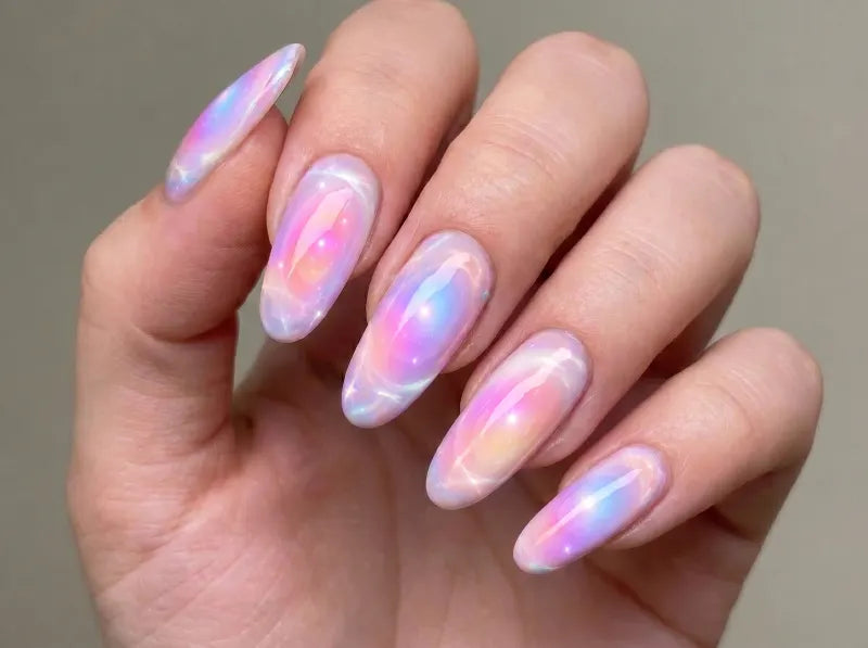 Hand with pastel gradient nail polish on a neutral background