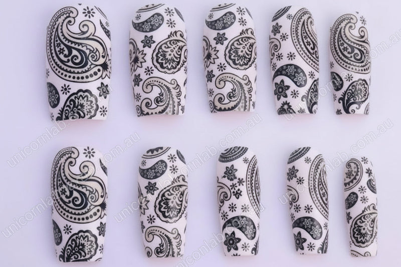 Black paisley patterned nails on a white background